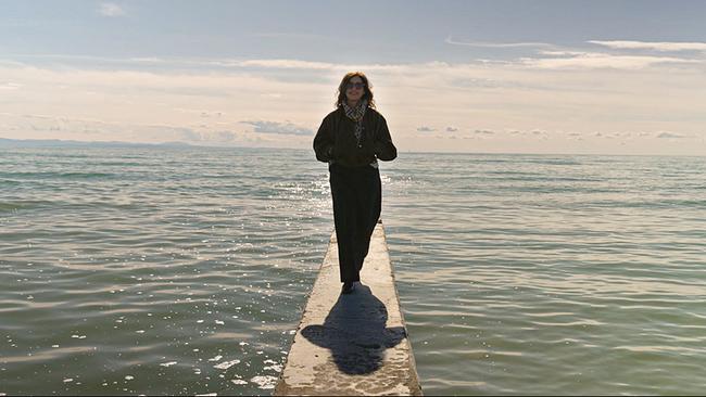 Julia Cencig steht auf einem Steg im Meer und blickt auf den Strand von Lignano.