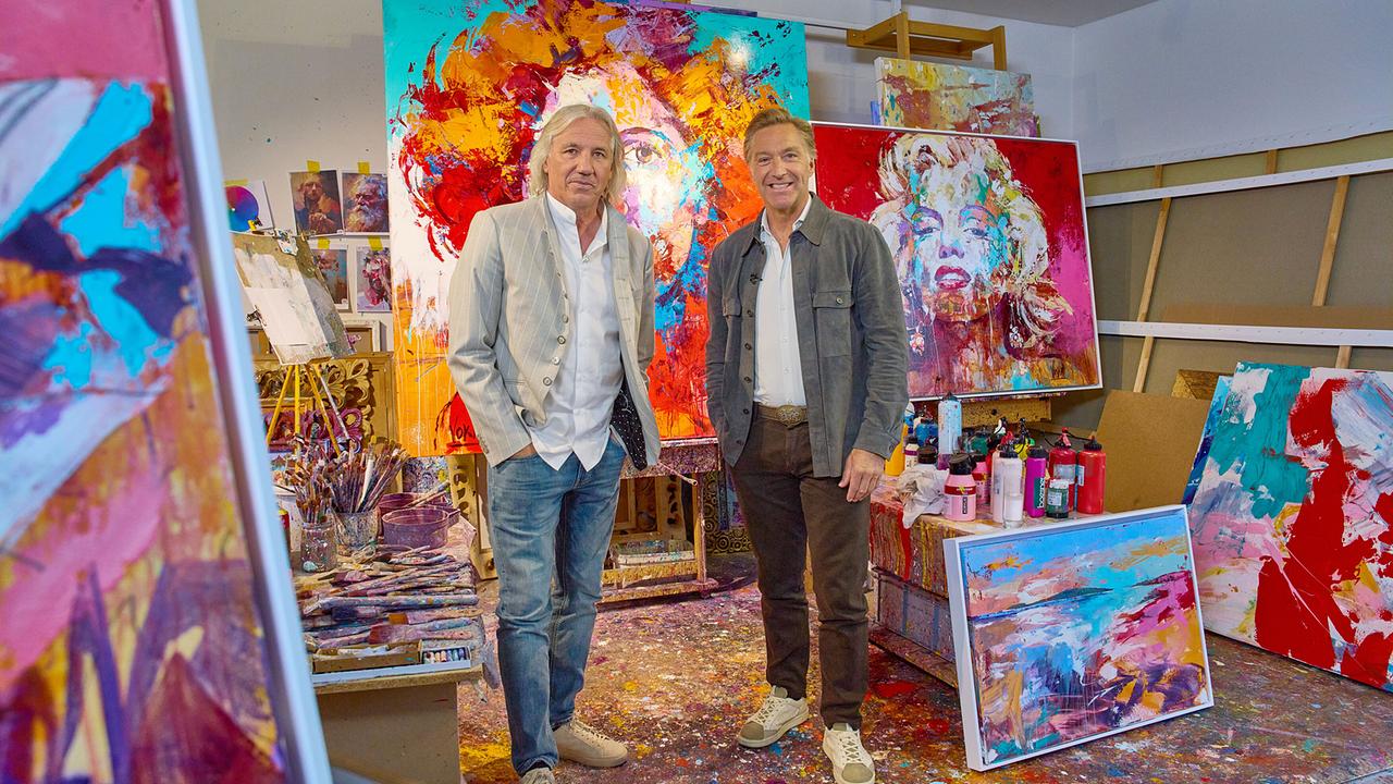 © ORF/Alois Kuschetz Hans Knauß und Rudolf Voka stehen in einem farbenfrohen Atelier zwischen großen abstrakten Gemälden und Malutensilien.