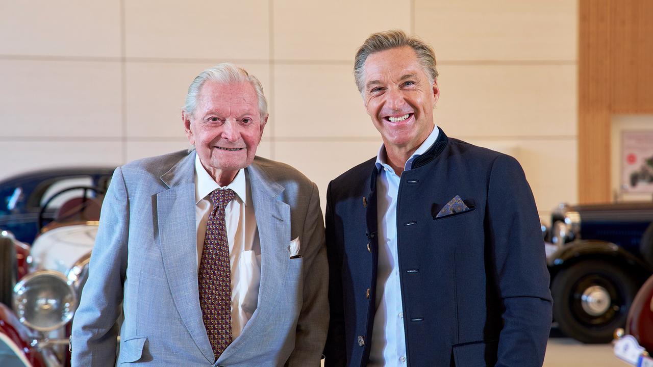 © ORF/Landesstudio Steiermark/Alois Kuschetz Ernst Piech und Hans Knauß posieren in einem hellen Raum vor prachtvollen historischen Oldtimern.