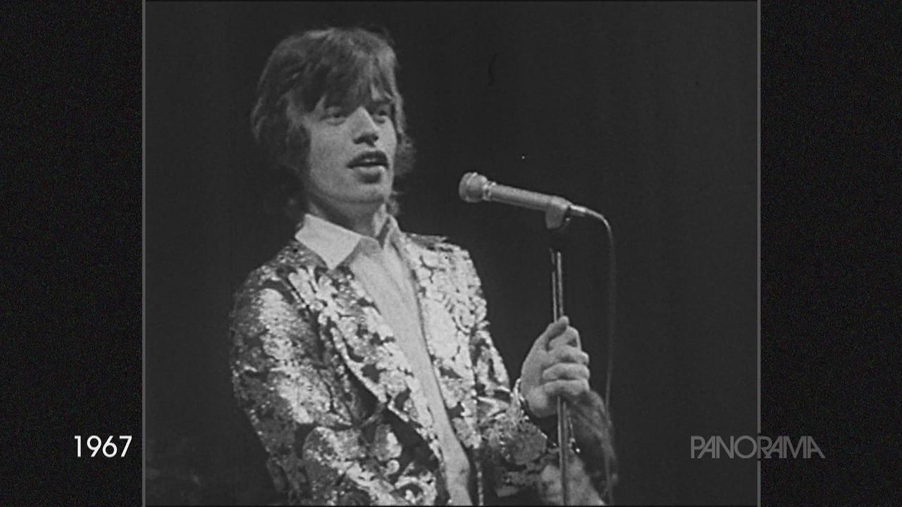 Mick Jagger steht vor einem Mikrofon bei einem Auftritt 1967.