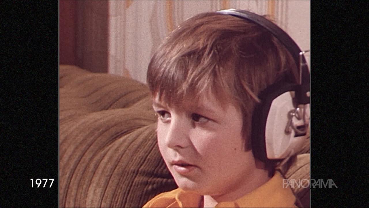 Am Bild aus dem Jahr 1977 ist ein Kind mit Kopfhörer zu sehen.