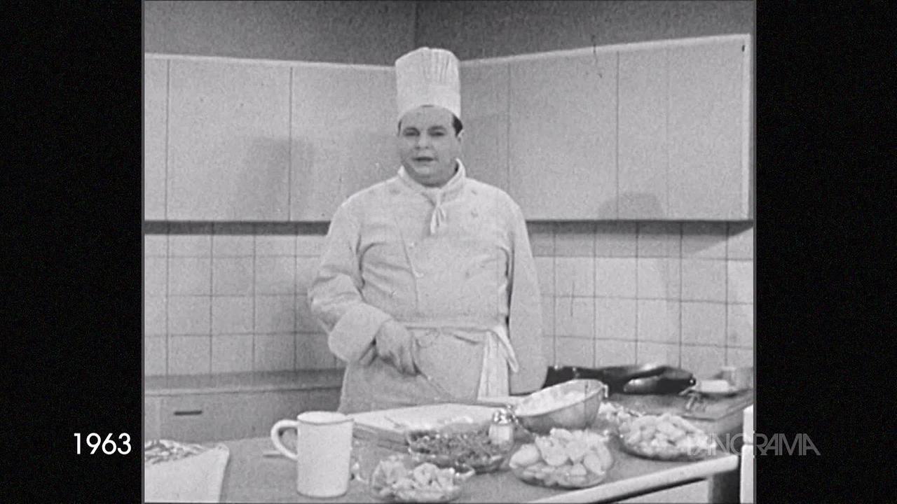 Am Bild aus dem Jahr 1963, ist der Fernsehkoch Misak mit Kochmütze und Kochgewand zu sehen. Er hat auf dem Küchentisch einige Schüsseln mit Zutaten stehen, die er verarbeiten möchte.