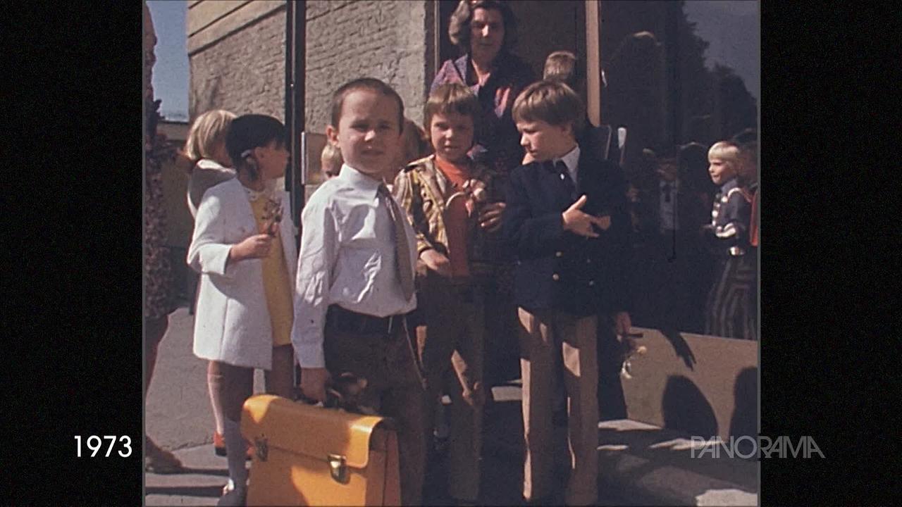 © ORF Am Bild aus dem Jahr 1973 sind Kinder am Eingang eines Hauses zu sehen. Sie sind hübsch angezogen. manche Buben sogar mit Krawatte, die Mädchen im Kleid und Rockerl.