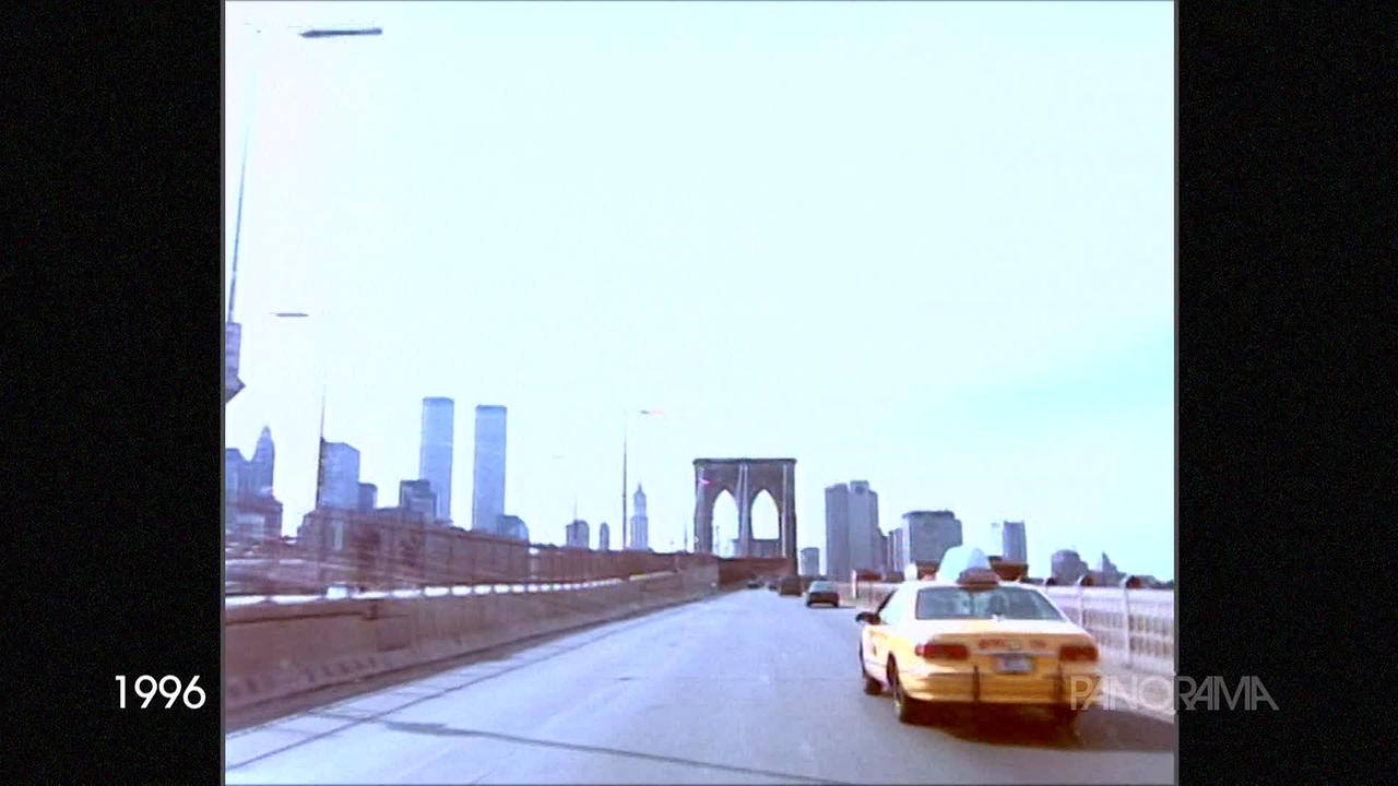 Am Bild aus dem Jahr 1996 ist die Brooklyn Bridge zu sehen. Ein für New York typisch gelbes Taxi fährt auf der rechten Spur. Im Hintergrund, in der Skyline, sieht man die Twin Towers des World Trade Centers, die es heute nicht mehr gibt.