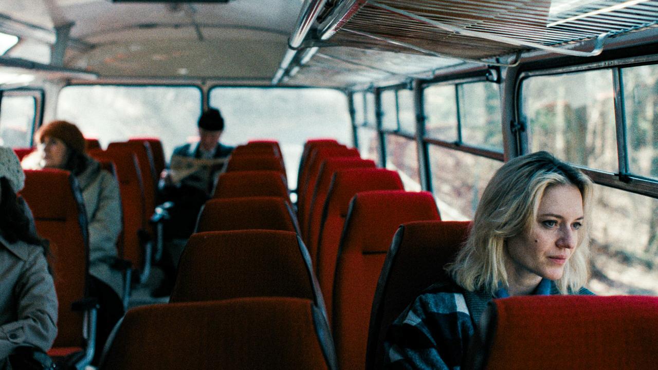© ORF/Stadtkino Filmverleih/Golden Girls Film Perla sitzt in einem Bus mit roten Sitzen und schaut aus dem Fenster.