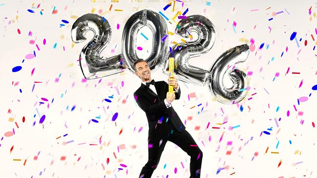 Florian Silbereisen steht vor großen „2026“-Ballons und sprüht Konfetti mit einer Dose in die Luft.