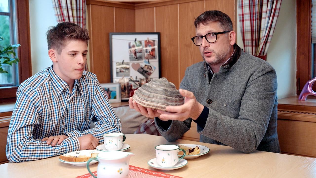 Wolfgang Huber und Sohn Matthias sitzen am Jausen-Tisch, halten einen riesigen Zunderschwamm in HÄnden.