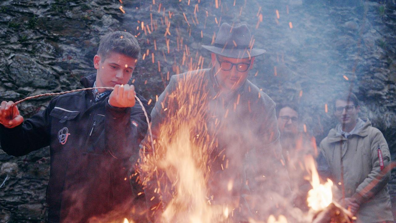 Matthias und Wolfgang Huber entzünden ihre Zunderschwämme am Osterfeuer.