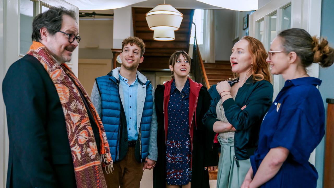 © ORF/BR/Cult Film/Petro Domenigg Edgar, Andreas, Hedwig, Balbina und Inka stehen im Eingangsbereich vor einer Holztreppe zusammen und sprechen miteinander.