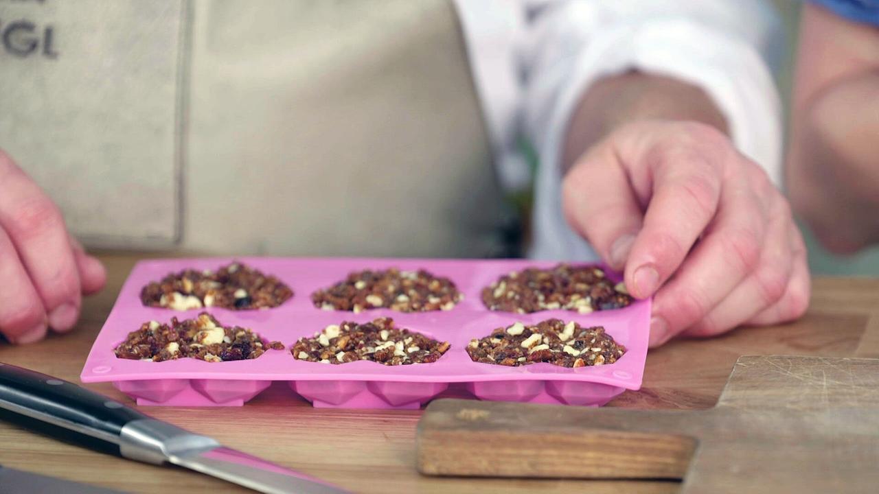 Selbstgemachte Proteinriegeln in rosa Silikonform auf einem Tisch