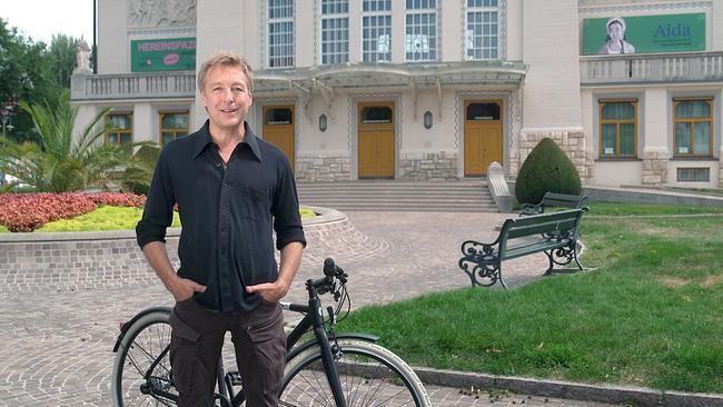 Max Müller steht mit seinem Rad vor dem Stadttheater in Klagenfurt.