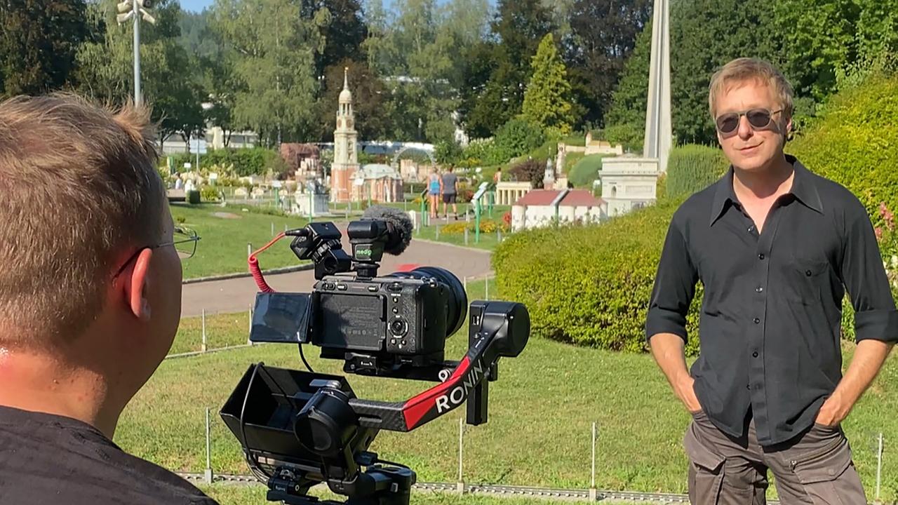 © ORF/Landesstudio Kärnten Max Müller steht bei Sonnenschein im Minimundus in Klagenfurt