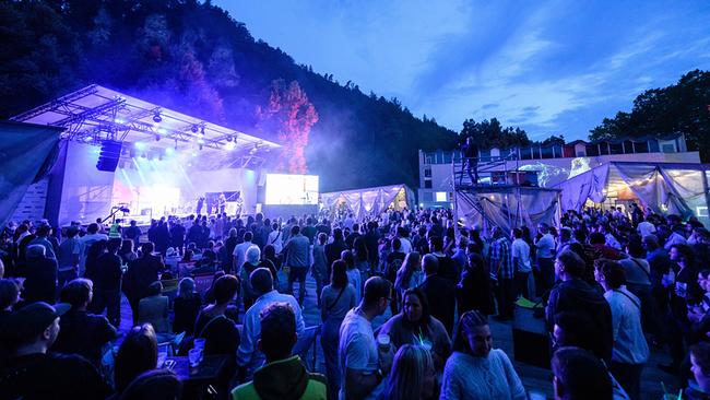 Sound@V Award-Show beim Poolbar Festival in Feldkirch mit einer  Menschenmenge vor einer hell erleuchteten Bühne in einer bewaldeten Abendkulisse
