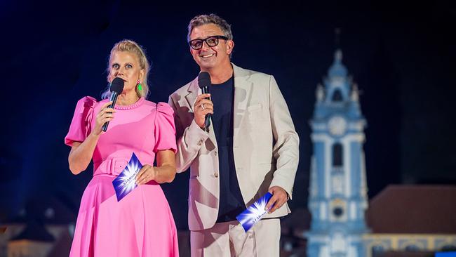 © ORF/ip|media/Peter Krivograd Barbara Schöneberger im pinken Kleid und Hans Sigl im hellen Anzug stehen mit Mikrofonen auf einer "Starnacht aus der Wachau"-Bühne vor einer nächtlichen Kulisse.