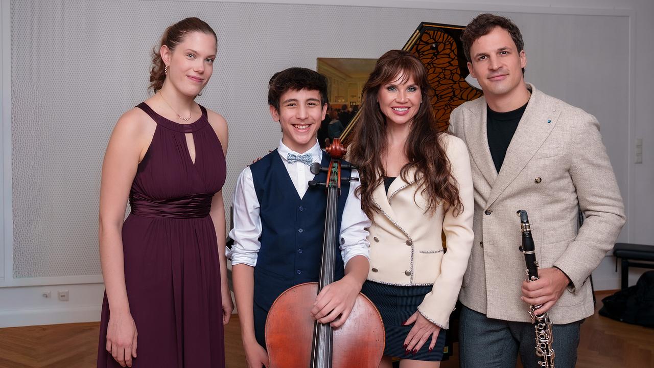 Ania Druml, Dylan Russell, Leona König und Andreas Ottensamer stehen elegant gekleidet mit Instrumenten vor einem Flügel und posieren für ein Gruppenfoto.