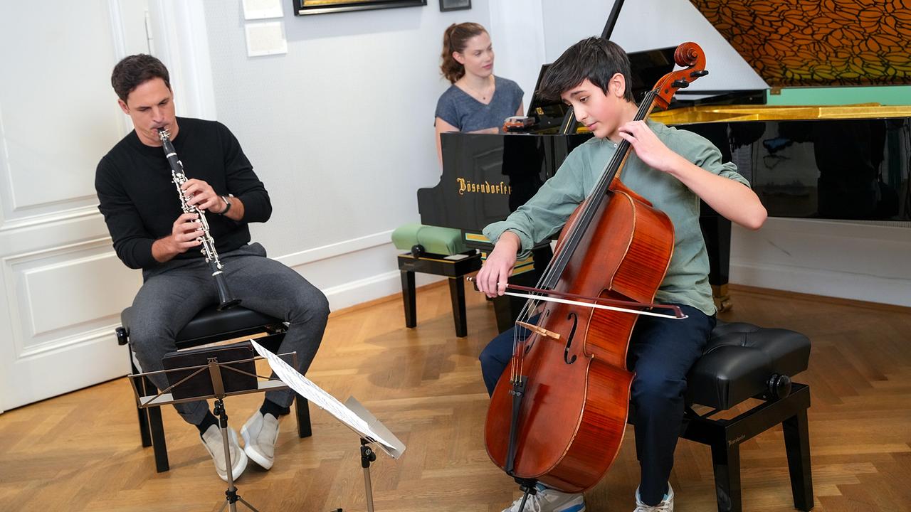 Andreas Ottensamer an der Klarinette, Ania Druml am Klavier und Ania Druml am Cello spielen gemeinsam in einem hellen Raum.