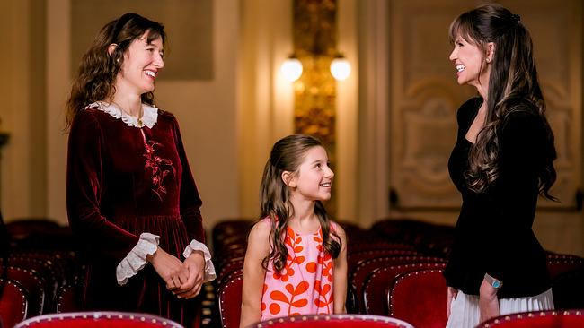 © ORF/Roman Zach-Kiesling Maddalena del Gobbo, Eloisa Aubert und Leona König stehen lächelnd zwischen roten Theatersitzen in einem prunkvollen Saal und unterhalten sich.
