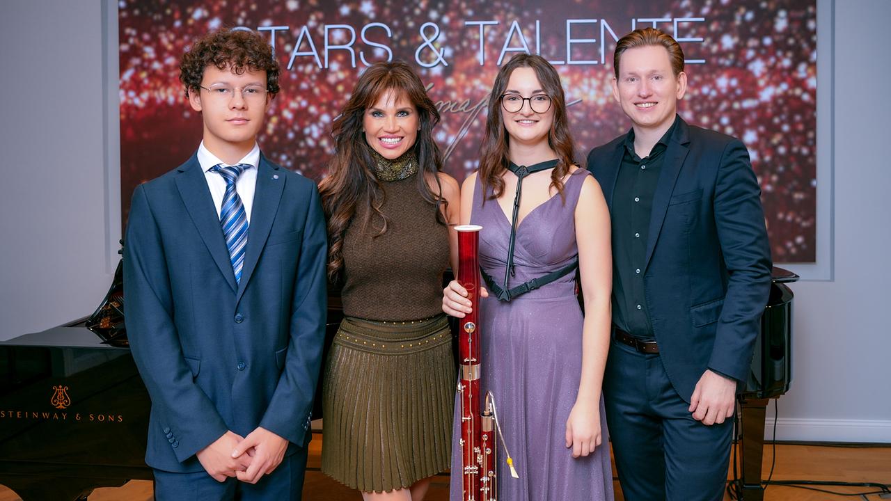 © ORF/Roman Zach-Kiesling David Kropfreiter, Leona König, Annalena Klem mit Fagott in der Hand und Bogdan Volkov, alle elegant gekleidet, posieren auf einer Bühne vor einem Klavier und einem „Stars & Talente“-Hintergrund.