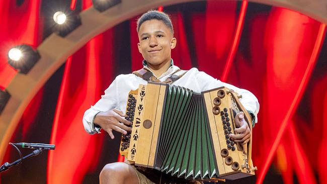 © ORF/Privat Philip Pscheidt in Tracht spielt eine Ziehharmonika auf einer beleuchteten Bühne.