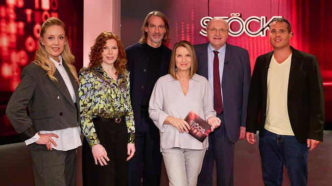 © ORF/Klaus Titzer Lilian Klebow, Teresa Vogl, Richard David Precht, Barbara Stöckl, Christoph Badelt und Boris David Seidl stehen gemeinsam im Fernsehstudio vor rotem Hintergrund mit "STÖCKL"-Schriftzug.