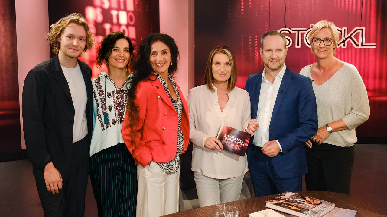 © ORF/Günther Pichlkostner Nils Arztmann, Jasmin Meiri-Brauer, Timna Brauer, Barbara Stöckl, Matthias Strolz und Birgit Fenderl stehen im Studio vor rotem Hintergrund mit "STÖCKL"-Schriftzug.