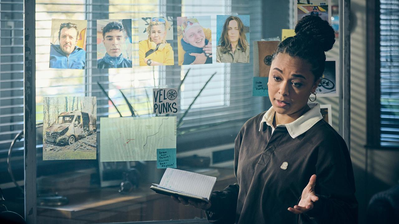 Mara hat das Vorleben der Mitglieder des Fahrradkollektivs Velopunks recherchiert und erklärt dies im Kommissariat vor einer Glaswand, an der Fotos, Skizzen und Notizen befestigt sind.