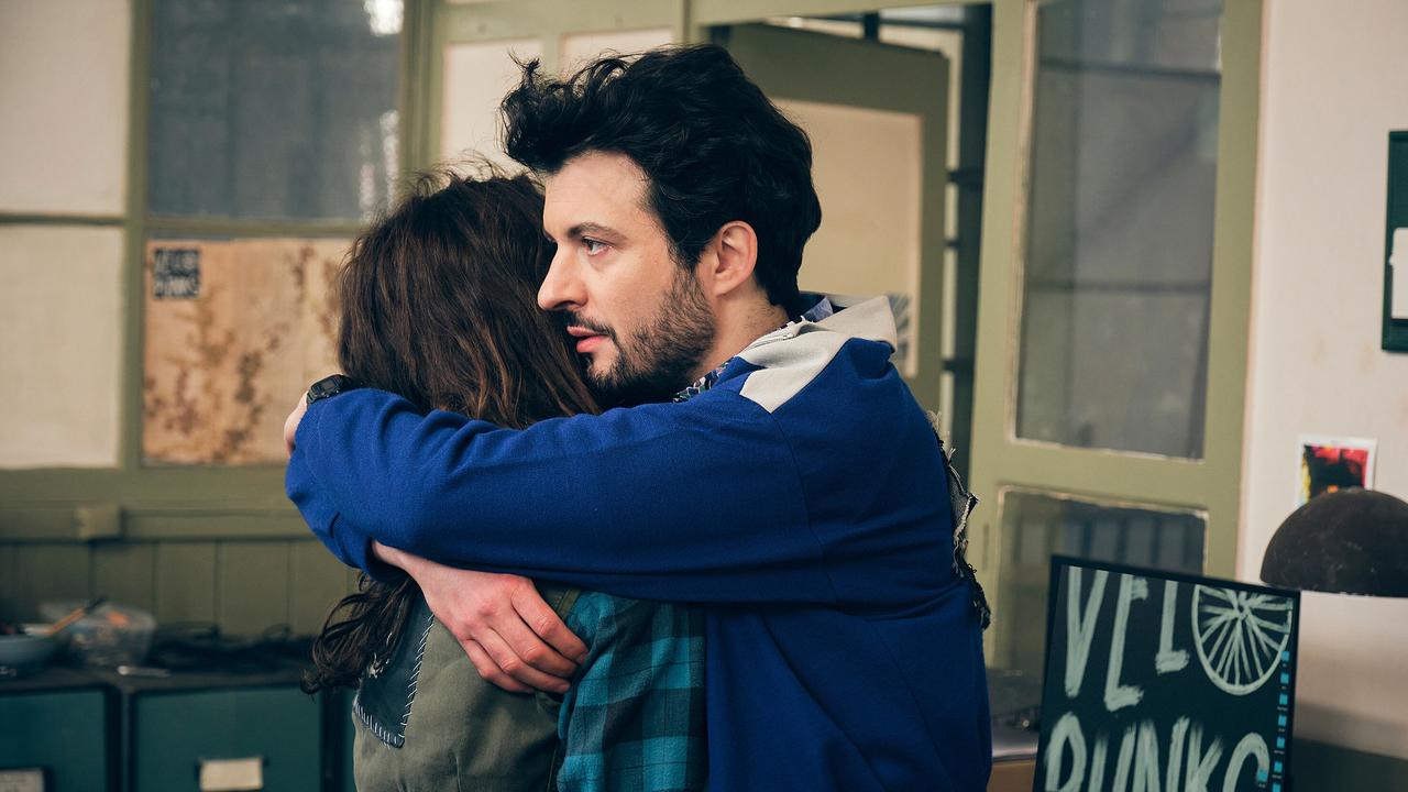 Theo und Zoe umarmen sich im Büro. Sie wollen versuchen, den Kurierdienst am Laufen zu halten.