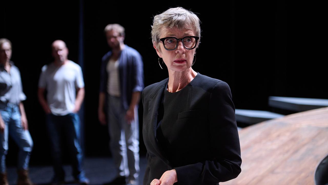 Intendantin Freya von Kaltenberg steht auf der Bühne im Vordergrund bei der Versammlung der Darsteller:innen.