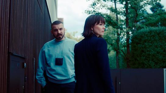 Hamza Kulina und Maryam Azadi stehen im Freien neben einem modernen Gebäude und einem Park.