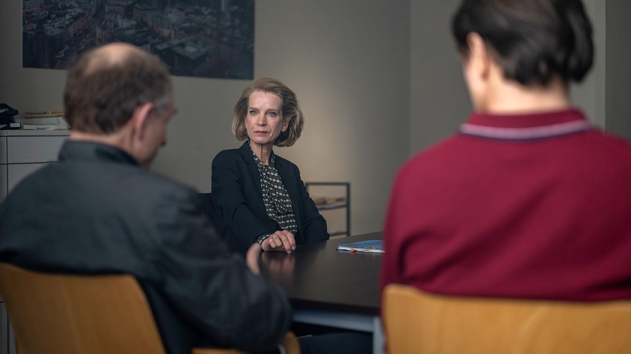 In einem Besprechungsraum sitzen Christian Möller, Sandra Schatz und Brombach an einem Tisch.