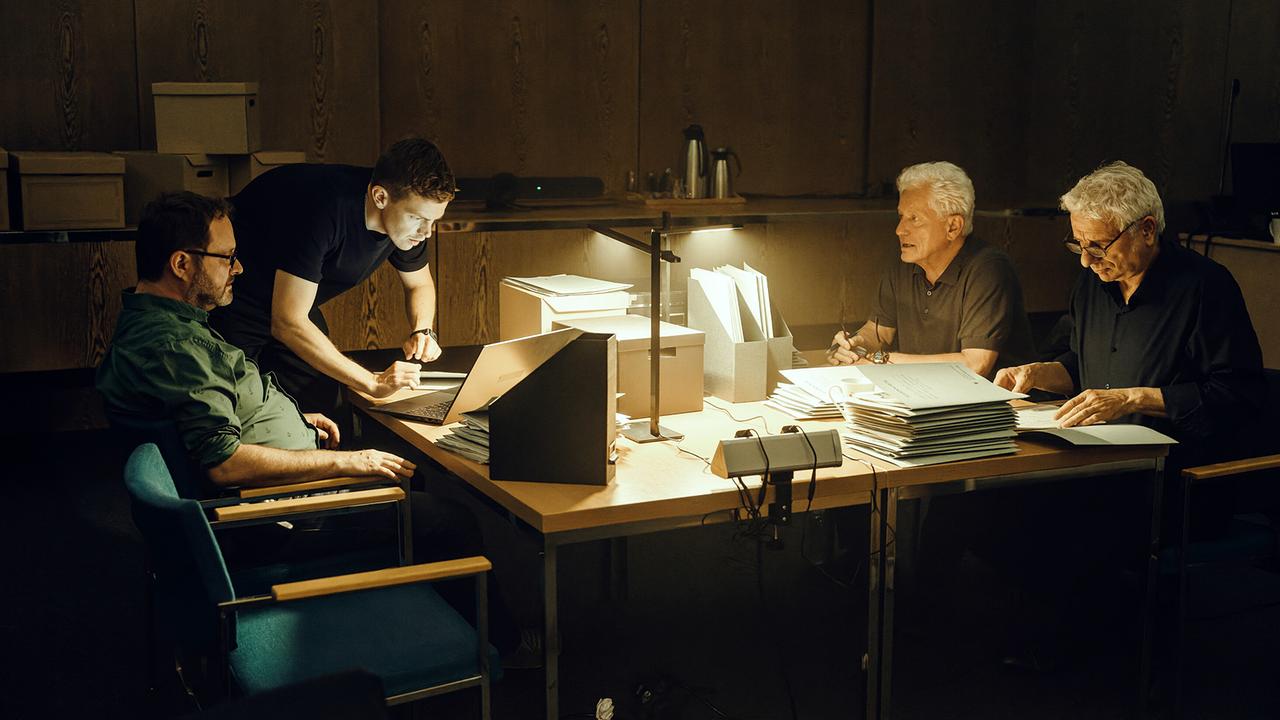 Ritschy Semmler, Kriminaloberkommissar Kalli Hammermann, Kriminalhauptkommissar Ivo Batic und Kriminalhauptkommissar Franz Leitmayr wühlen sich nachts an ihren Schreibtischen durch die Akten.