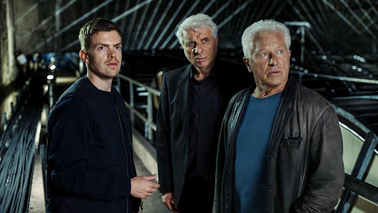 Kalli Hammermann, Franz Leitmayr und Ivo Batic stehen in einem dunklen Schacht unter dem St. Quirin Platz