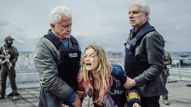 Ivo Batic und Franz Leitmayr in Schutzwesten halten die verzweifelte Kara Roth auf dem Dach des Klinikums, während weitere Einsatzkräfte die Umgebung sichern.