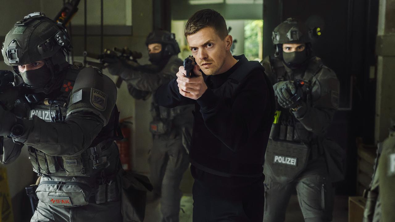 Kalli Hammermann sichert mit den SEK Beamten im Einsatz in der Stauwehrhalle mit gezogenen Waffen einen Innenraum bei einem Einsatz.