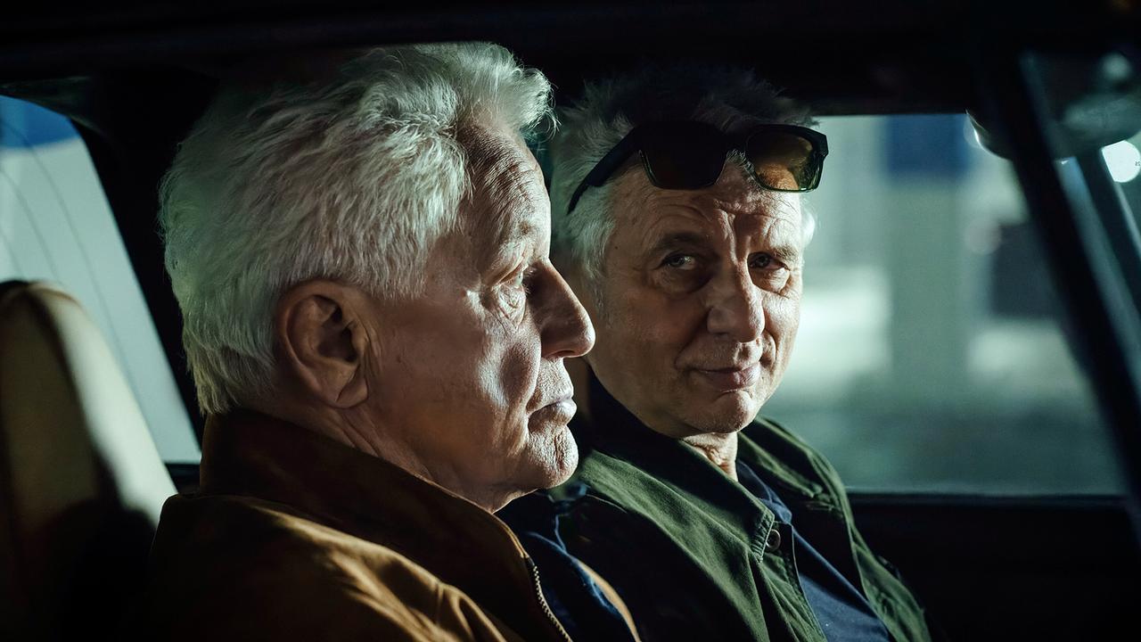 Ivo Batic und Franz Leitmayr sitzen im Porsche in der Tiefgarage und beobachten die Mitarbeiter von Prime Wave.