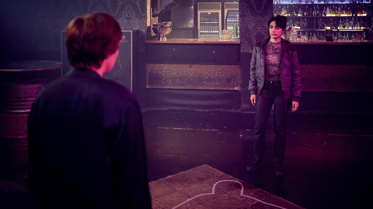 Franziska Tobler und Ella Pauls stehen sich in einem dunklen Club gegenüber, am Boden ist eine Leichenumriss-Markierung zu sehen.