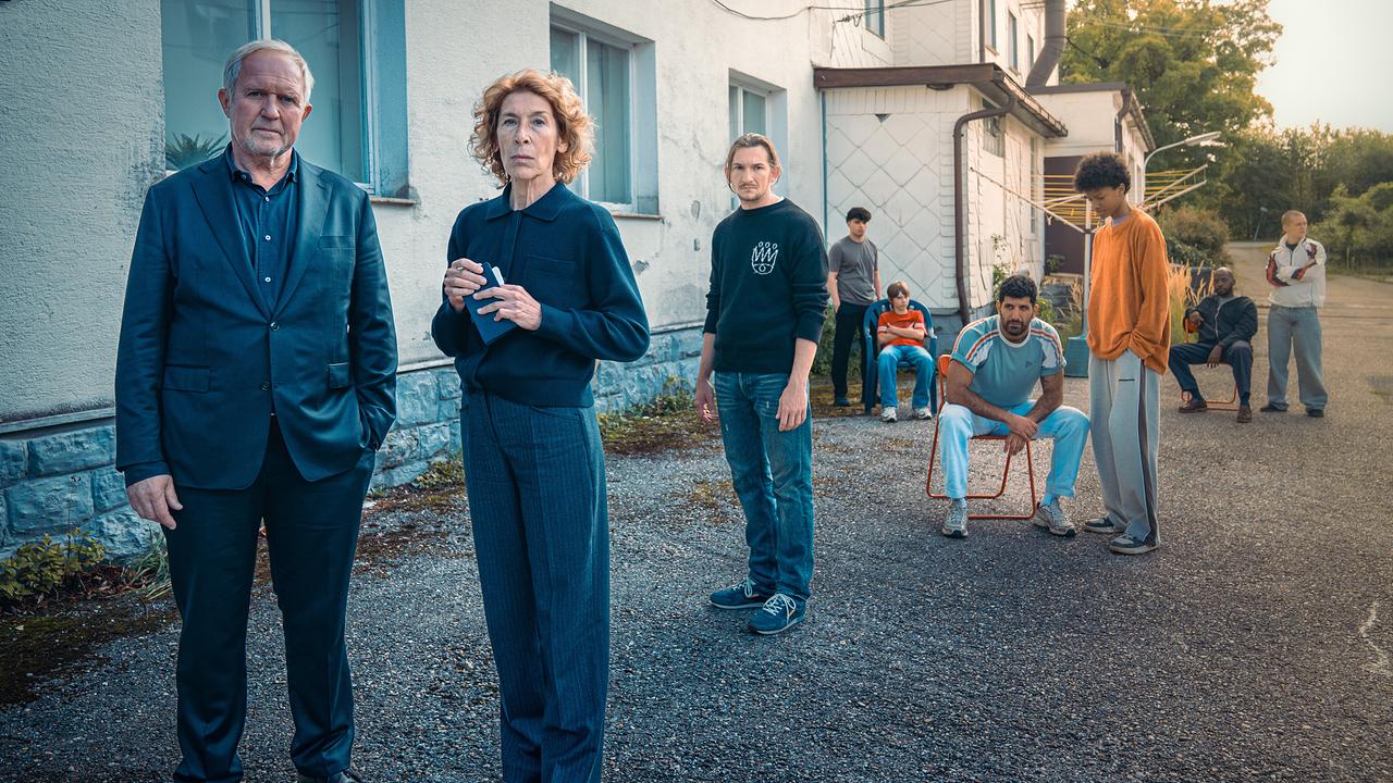 Moritz Eisner und Bibi Fellner stehen vor dem Sonnenhof mit Betreuern und den jugendlichen Bewohnern im Hintergrund.