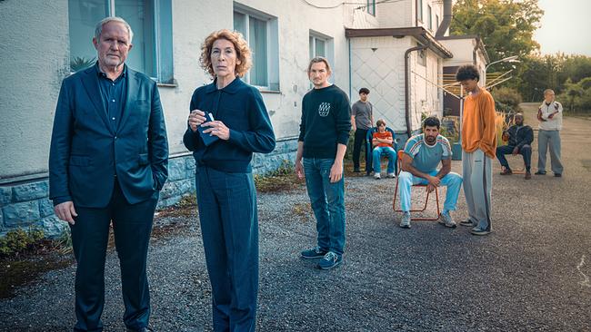 © ORF/Petro Domenigg Moritz Eisner und Bibi Fellner stehen vor dem Sonnenhof mit Betreuern und den jugendlichen Bewohnern im Hintergrund.