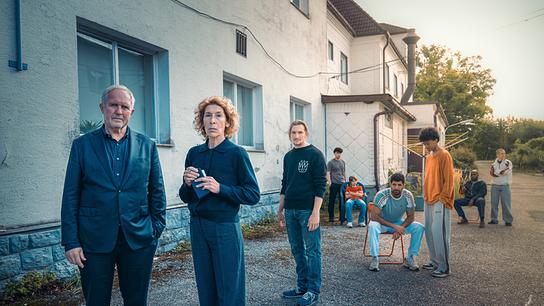 Moritz Eisner und Bibi Fellner stehen vor dem Sonnenhof mit Betreuern und den jugendlichen Bewohnern im Hintergrund.