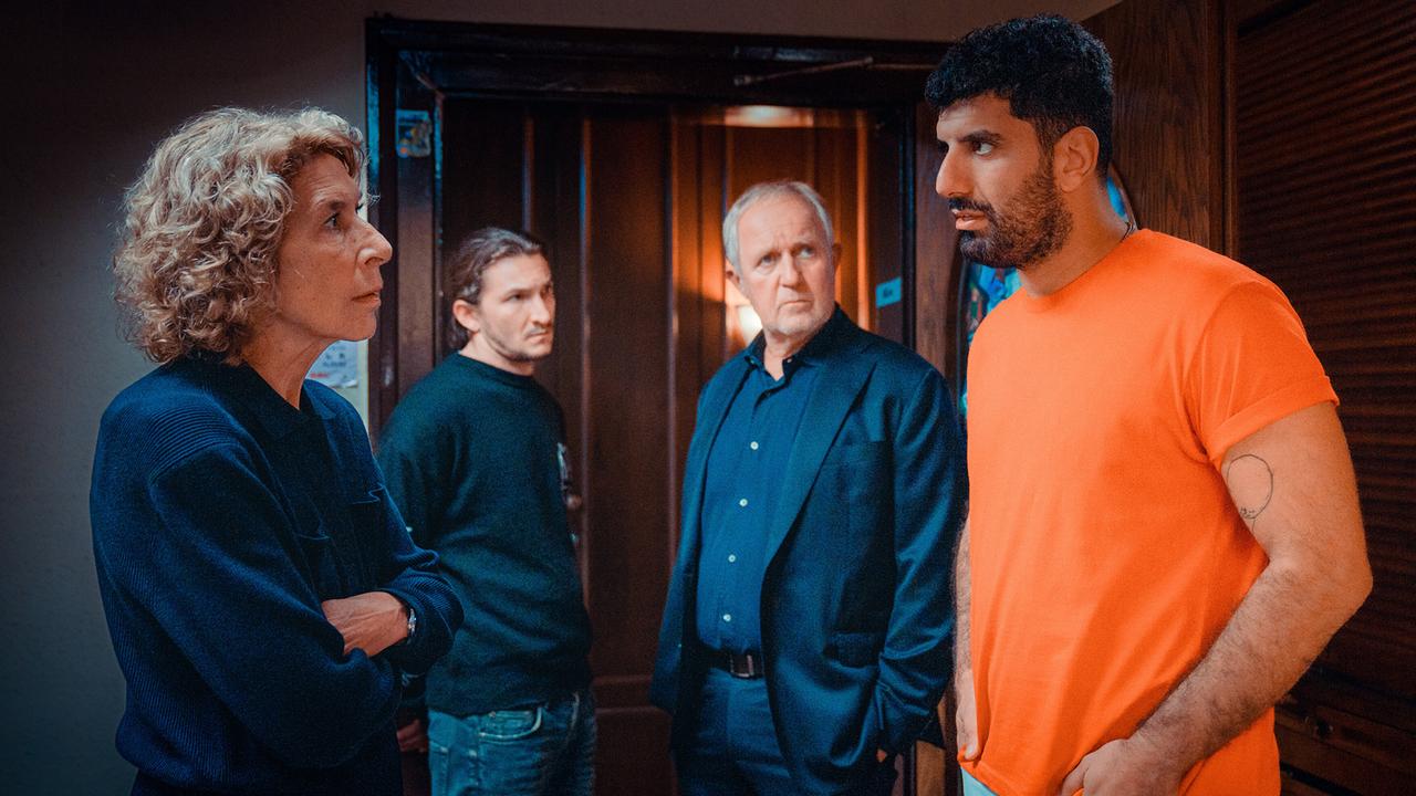 Bibi Fellner und Moritz Eisner stehen mit den Betreuern Simon Rechnik und Araz Barzani in einem beleuchteten Flur.