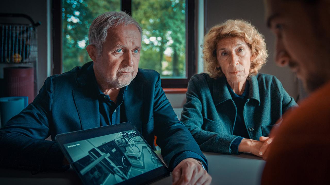 Moritz Eisner und Bibi Fellner  sitzen mit Simon Rechnik an einem Tisch, und zeigen ihm eine Bilddarstellung auf einem Tablet.