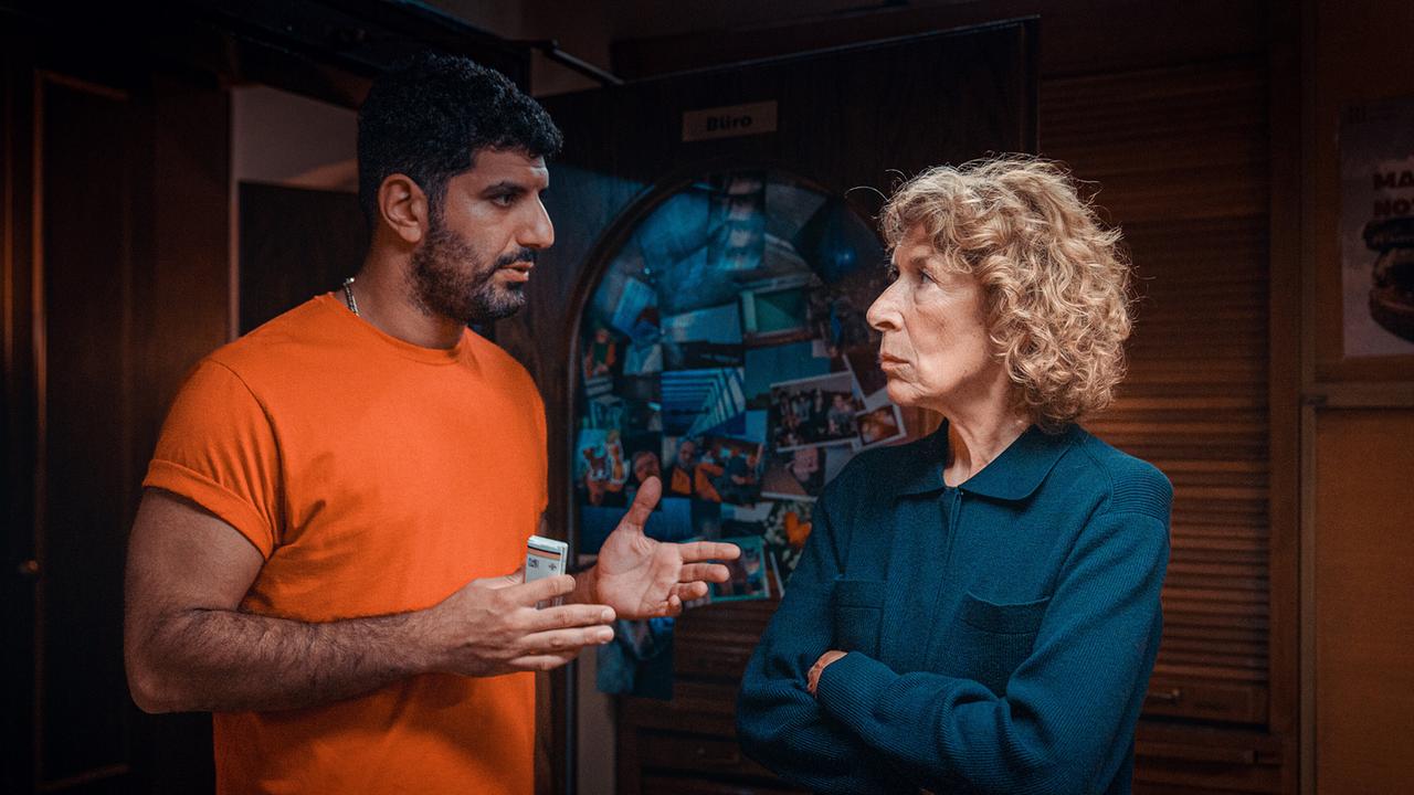 Araz Barzani im Gespräch mit Bibi Fellner in einem dunklen holzvertäfelten Raum.