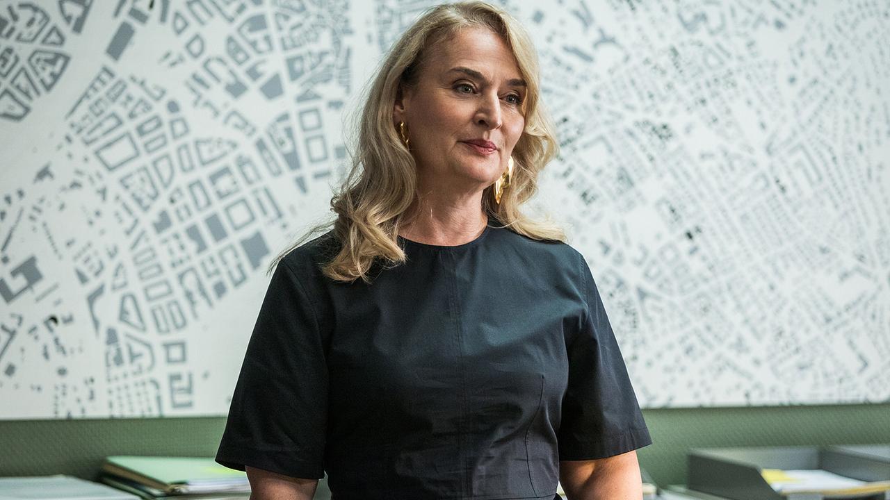 Staatsanwältin Anita Wegenast steht in einem Büro vor einer Wand mit Kartenmotiv.