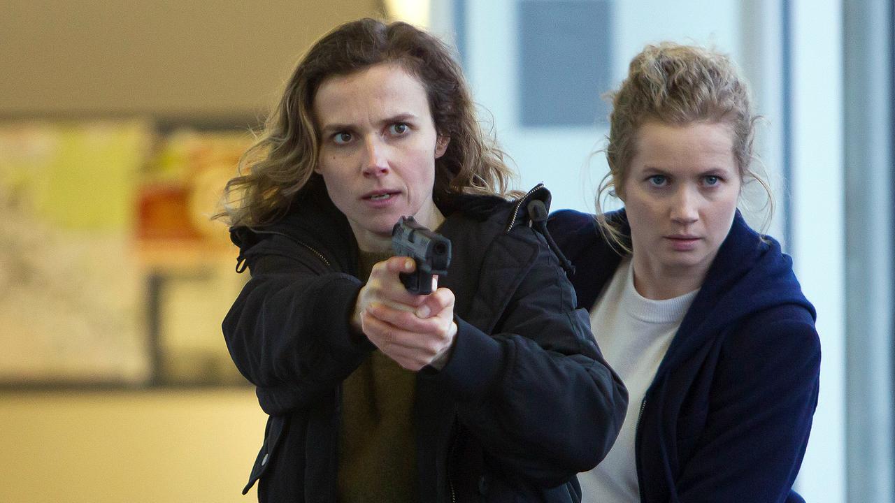 Karin Gorniak mit gezogener Waffe, dahinter Leo Winkler in einem hellen Flur.