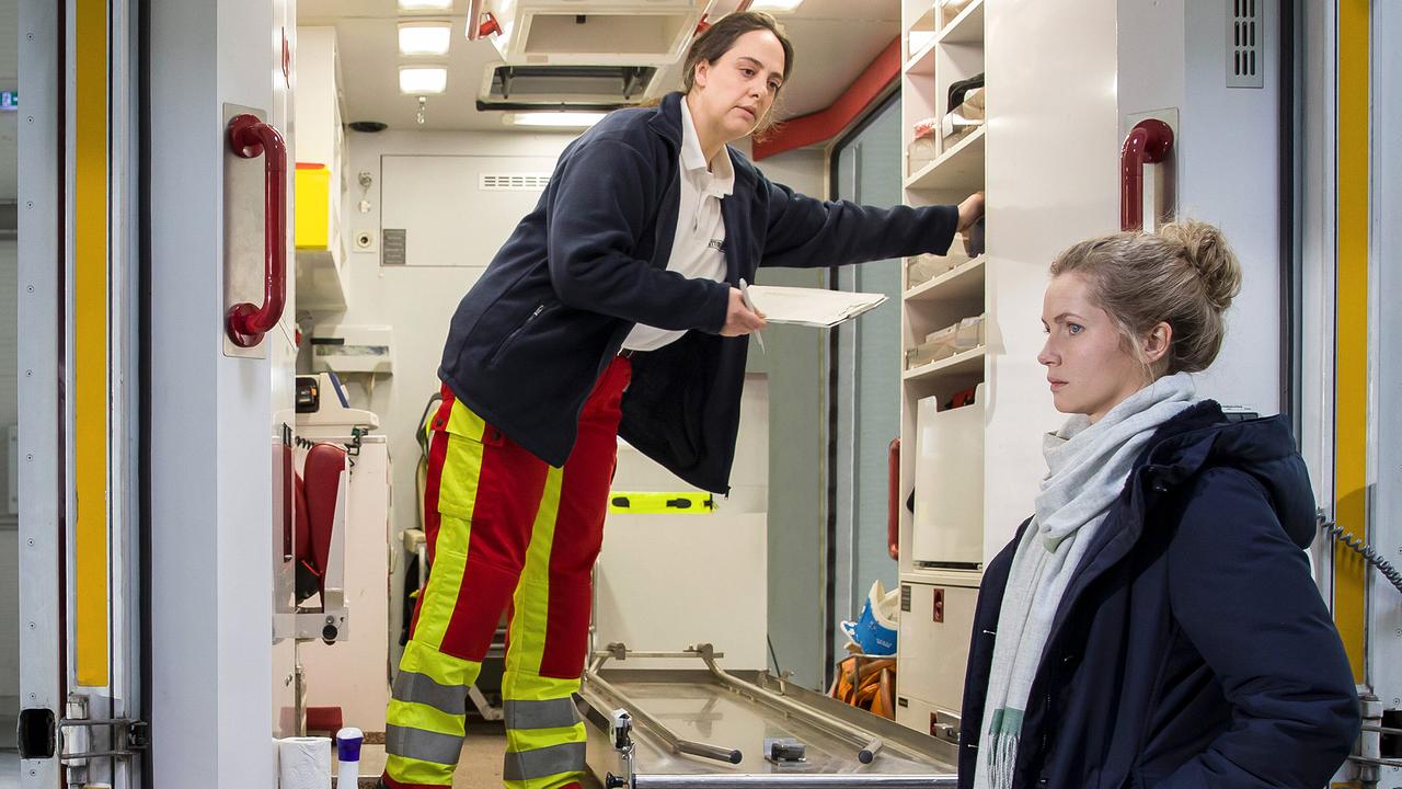 Sanitäterin Elena Jancowicz bereitet im Rettungswagen medizinisches Material vor, während  Leonie "Leo" Winkler davorsteht.