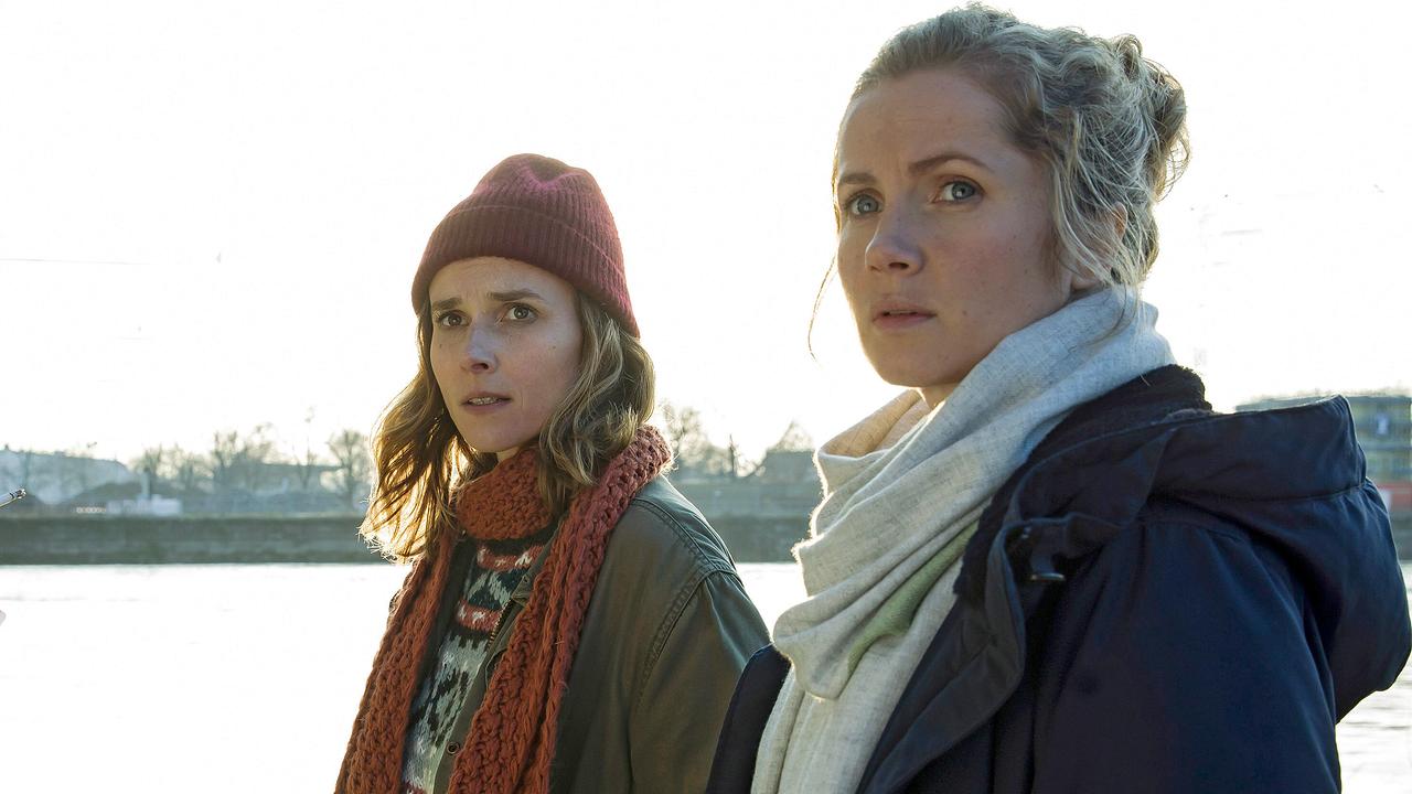 Karin Gorniak und Leo Winkler stehen warm angezogen am Ufer der Elbe und blicken in die Ferne.