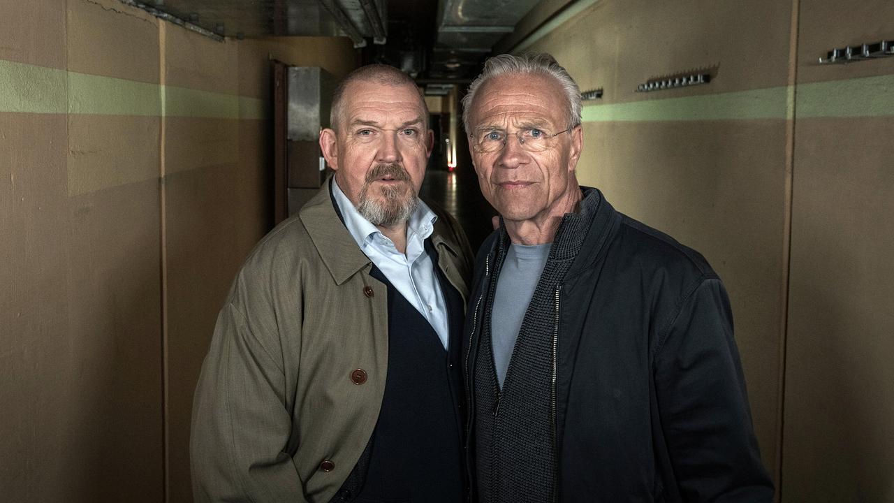 Die Kommissare Max Ballauf und Freddy Schenk stehen in einem schmalen, düster beleuchteten Gang.