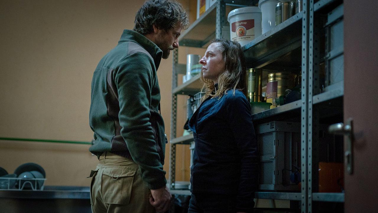 Elara Schmidtke hat den Survivaltrainer Moritz Zechmann herausgefordert und stehen sich im Bunker vor einem Vorratsregal sehr nahe gegenüber. 