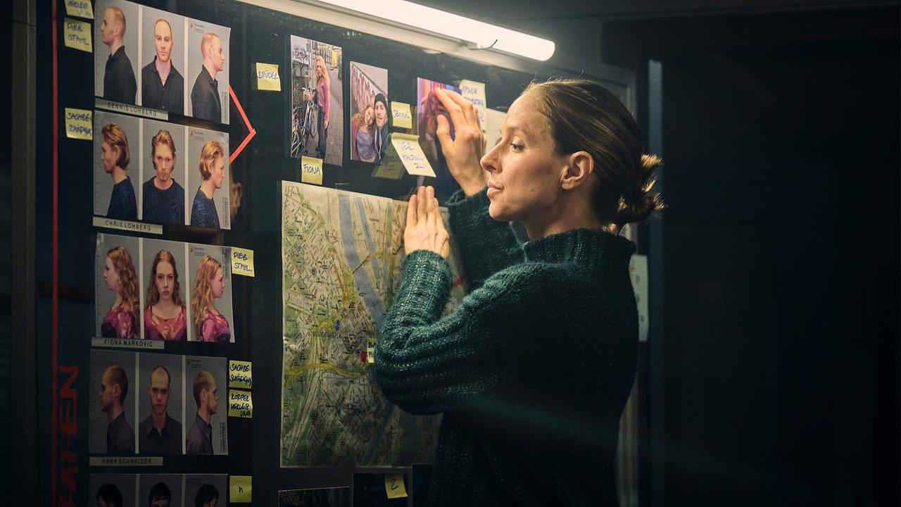 Johanna Stern ergänzt an einer großen Tafel mit Fotos, Notizzetteln und Stadtplan ihre Recherche.