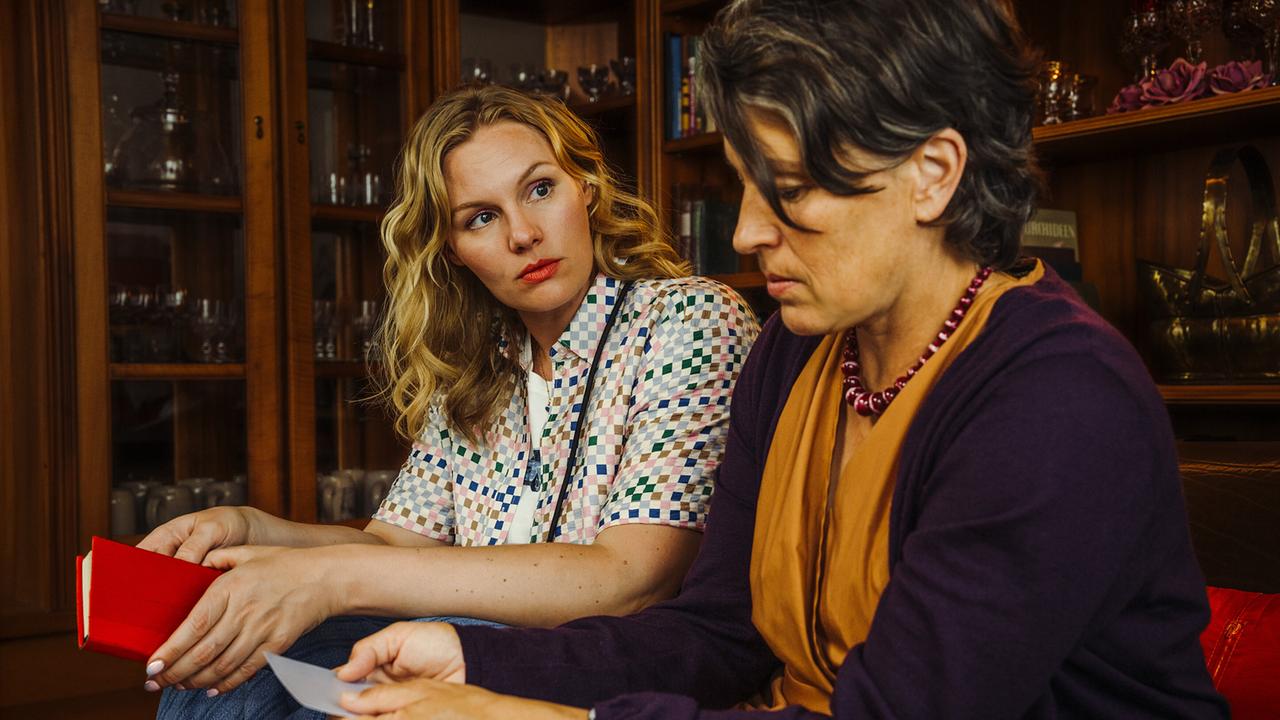 Emmy Rathgeber und Frau Schaller sitzen nebeneinander auf einer Coach im Haus Schaller in Gottesgarten.
